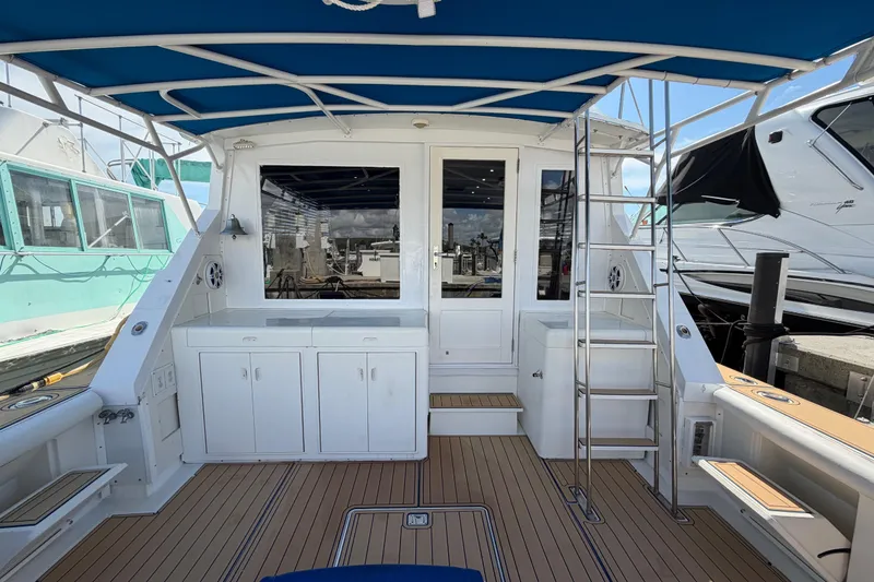Slide: The Image of 1986 Bertram 46 Convertible yacht deck with blue canopy and white cabinetry. - 53