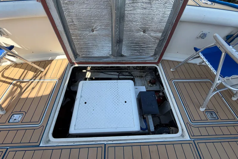 Slide: The Image of Open engine hatch on 1986 Bertram 46 Convertible boat, revealing mechanical components. - 54