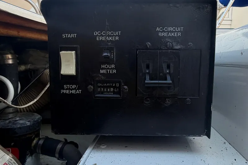 Slide: The Image of Control panel of a 1986 Bertram 46 Convertible boat with circuit breakers and hour meter. - 57