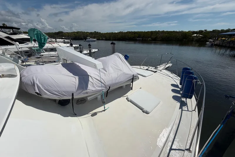 Slide: The Image of 1986 Bertram 46 Convertible yacht docked, featuring covered equipment on deck. - 59