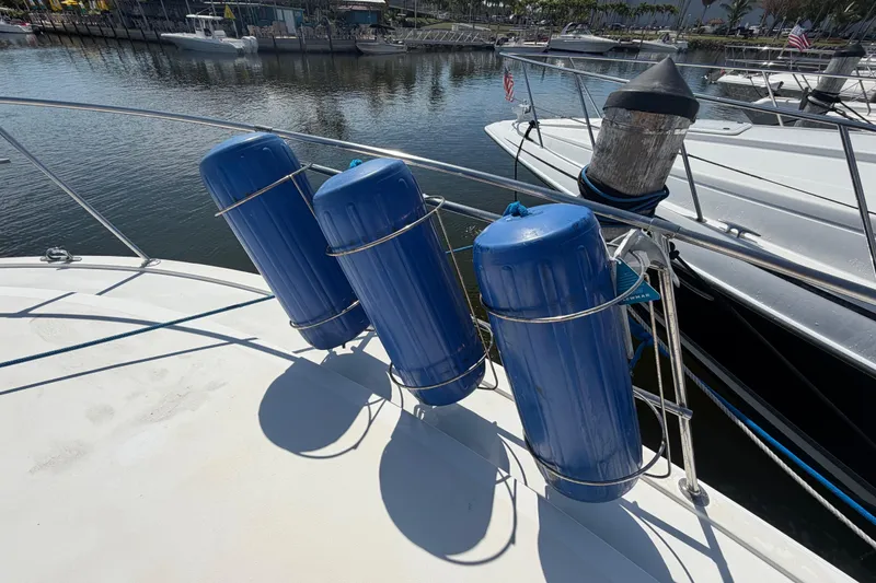 Slide: The Image of Blue fenders on a 1986 Bertram 46 Convertible yacht docked at a marina. - 60