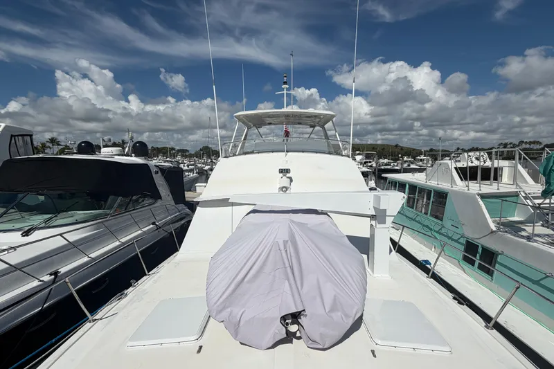 Slide: The Image of 1986 Bertram 46 Convertible yacht docked at marina under a partly cloudy sky. - 63