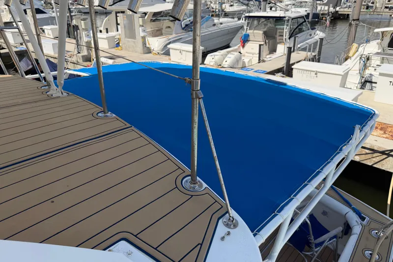Slide: The Image of 1986 Bertram 46 Convertible yacht with blue canvas cover at marina. - 66
