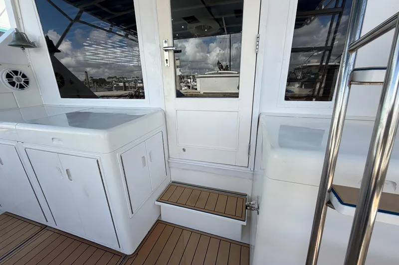 Slide: The Image of 1986 Bertram 46 Convertible yacht deck with white cabinetry and stainless steel railing. - 67