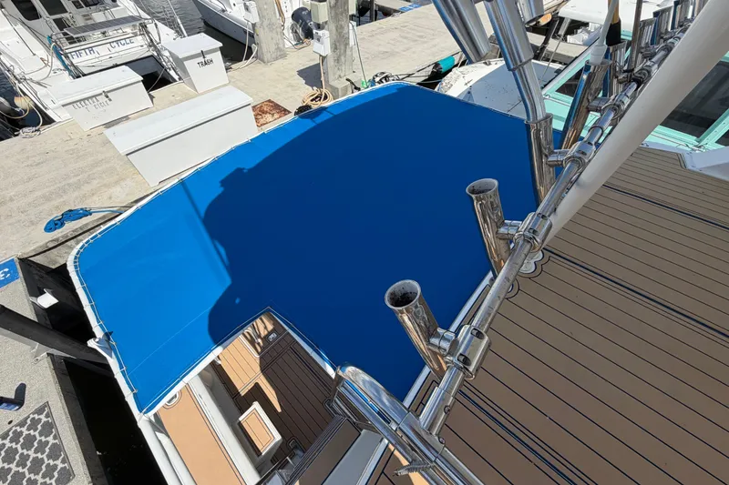 Slide: The Image of 1986 Bertram 46 Convertible yacht with blue canopy and rod holders at dock. - 71