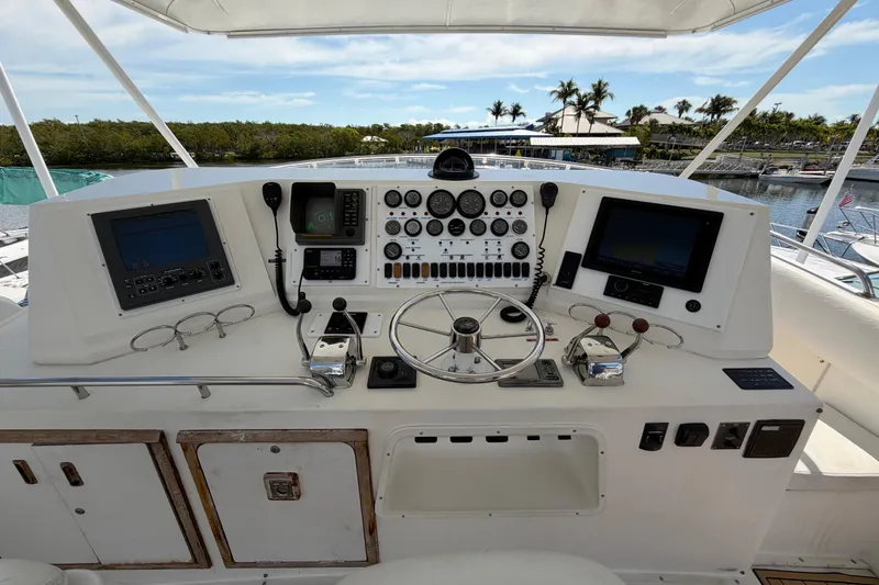 Slide: The Image of Control panel of a 1986 Bertram 46 Convertible yacht with steering wheel and navigation instruments. - 73