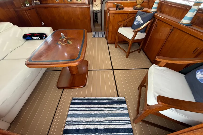 Slide: The Image of Interior of 1986 Bertram 46 Convertible yacht with wooden furniture and striped rug. - 8