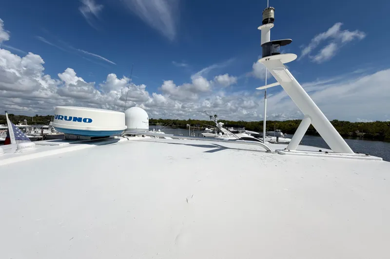 Slide: The Image of 1986 Bertram 46 Convertible yacht deck with radar equipment under a clear blue sky. - 85