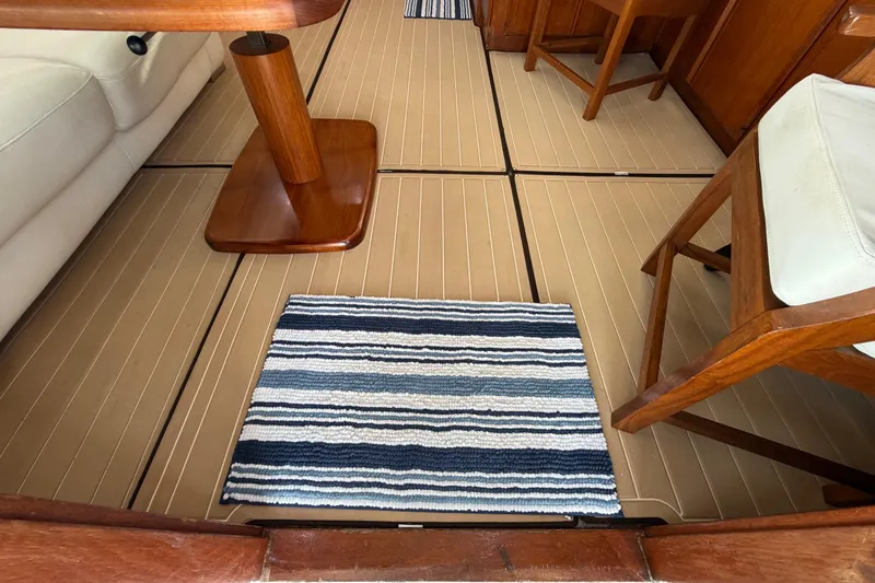 Slide: The Image of Interior of 1986 Bertram 46 Convertible with wooden furniture and striped rug. - 9