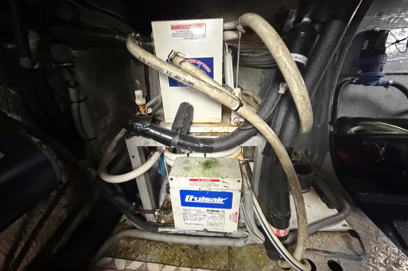 Slide: The Image of Engine room of a 1986 Bertram 46 Convertible with Cruisair equipment and various hoses. - 94