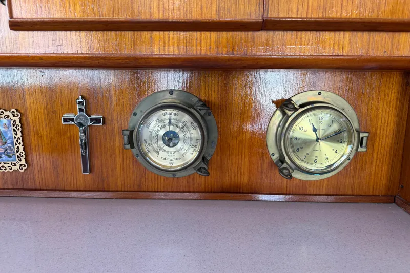 Slide: The Image of Wooden panel with barometer, clock, cross, and decorative picture on Bertram 46 Convertible, 1986. - 97