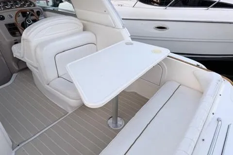 Slide: The Image of 1999 Sea Ray 290 Sundancer boat interior with white seating and table. - 10