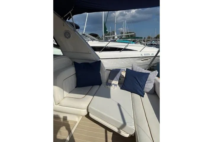 Slide: The Image of 1999 Sea Ray 290 Sundancer boat interior with white seating and blue cushions. - 12