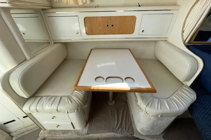 Slide: The Image of 1999 Sea Ray 290 Sundancer interior with white seating, docked among other boats. - 18