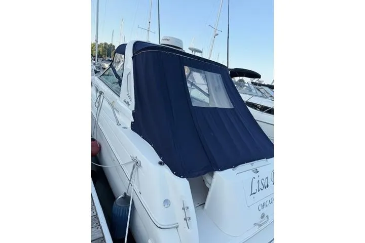 Slide: The Image of 1999 Sea Ray 290 Sundancer docked with navy blue cover. - 2