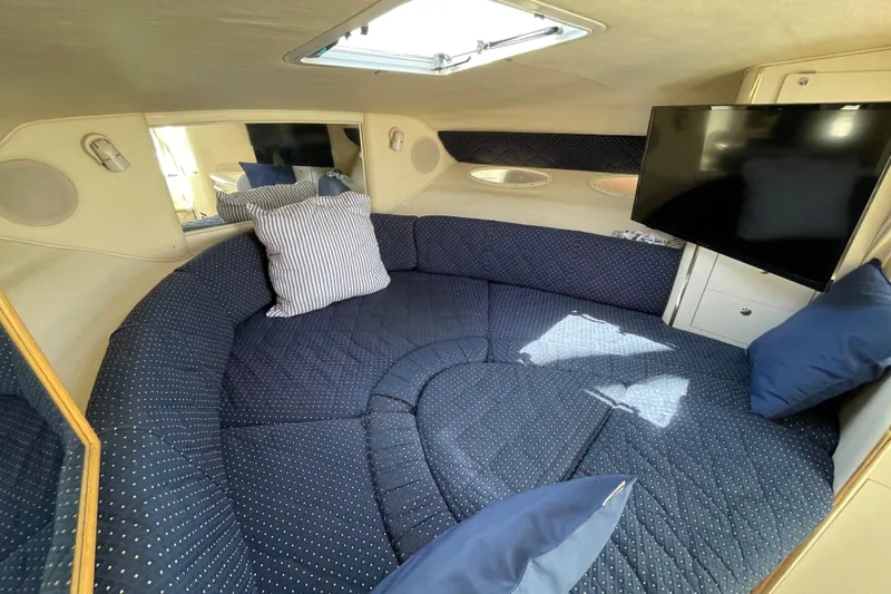 Slide: The Image of 1999 Sea Ray 290 Sundancer boat with canopy, docked under clear blue sky. - 23