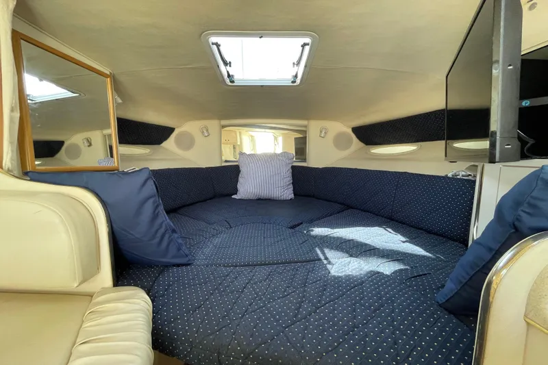 Slide: The Image of Interior of a 1999 Sea Ray 290 Sundancer with a cozy dining area and storage cabinets. - 29