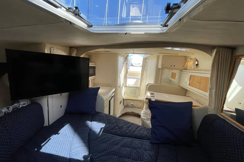 Slide: The Image of 1999 Sea Ray 290 Sundancer cabin interior with bed, shelves, and reading light. - 31