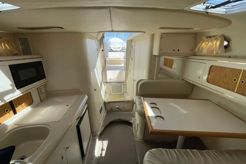 Slide: The Image of Interior of 1999 Sea Ray 290 Sundancer boat with kitchenette and seating area. - 36