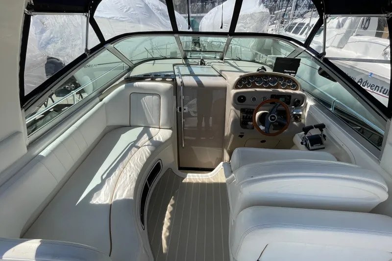 Slide: The Image of 1999 Sea Ray 290 Sundancer cockpit with white seating and modern dashboard. - 8