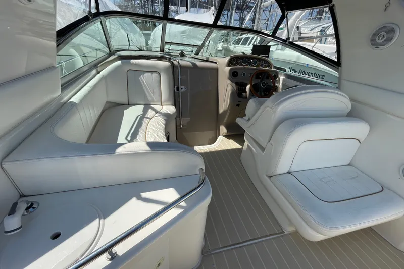 Slide: The Image of 1999 Sea Ray 290 Sundancer boat interior with white seating and steering wheel. - 9