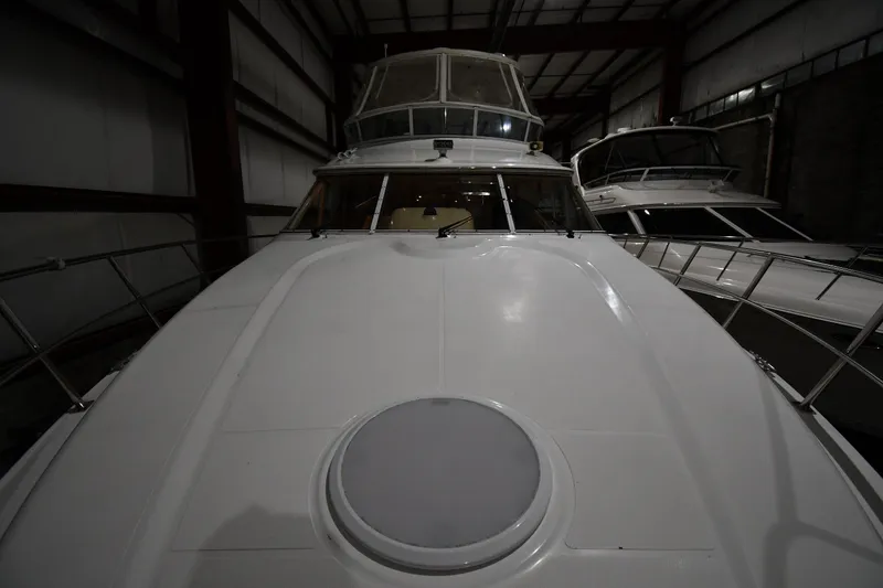 Slide: The Image of 2003 Cruisers Yachts 5000 Sedan Sport in storage, showcasing sleek design and spacious deck. - 10