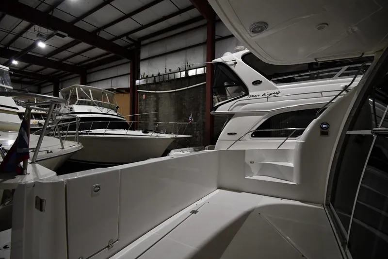 Slide: The Image of 2003 Cruisers Yachts 5000 Sedan Sport docked in a spacious indoor marina. - 14