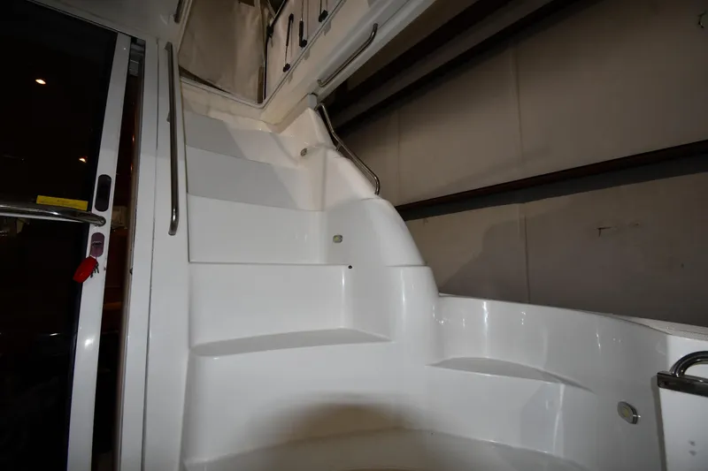 Slide: The Image of Staircase inside 2003 Cruisers Yachts 5000 Sedan Sport, featuring sleek white design. - 16