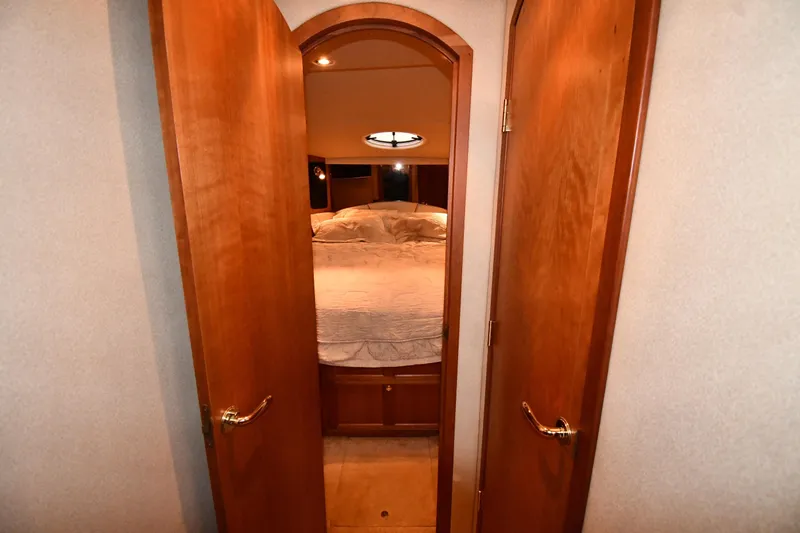 Slide: The Image of 2003 Cruisers Yachts 5000 Sedan Sport cabin interior with wooden doors and cozy bed. - 32
