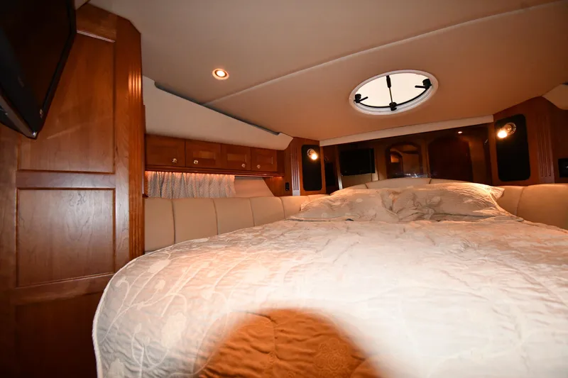 Slide: The Image of Luxurious bedroom interior of 2003 Cruisers Yachts 5000 Sedan Sport with wood paneling. - 35