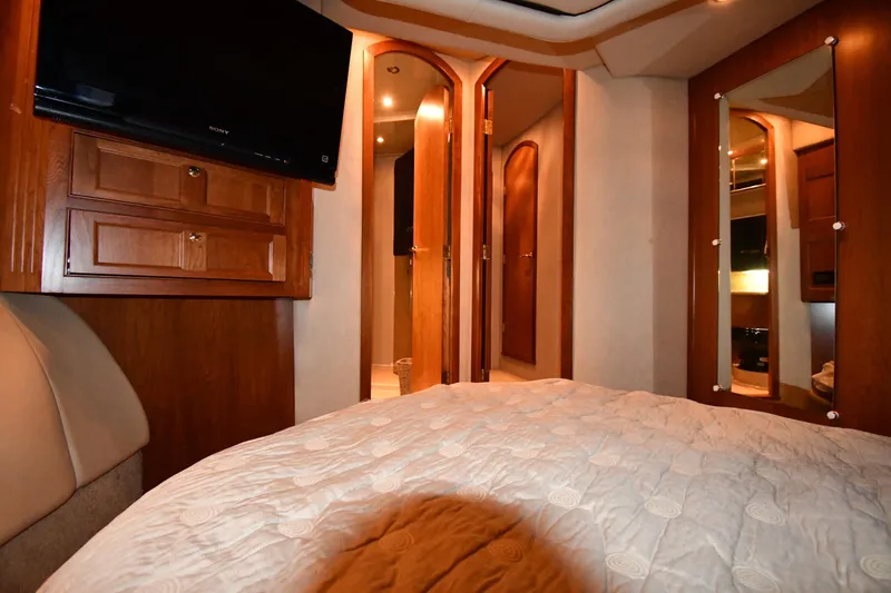 Slide: The Image of Luxurious interior of 2003 Cruisers Yachts 5000 Sedan Sport with wood accents and cozy bedding. - 45