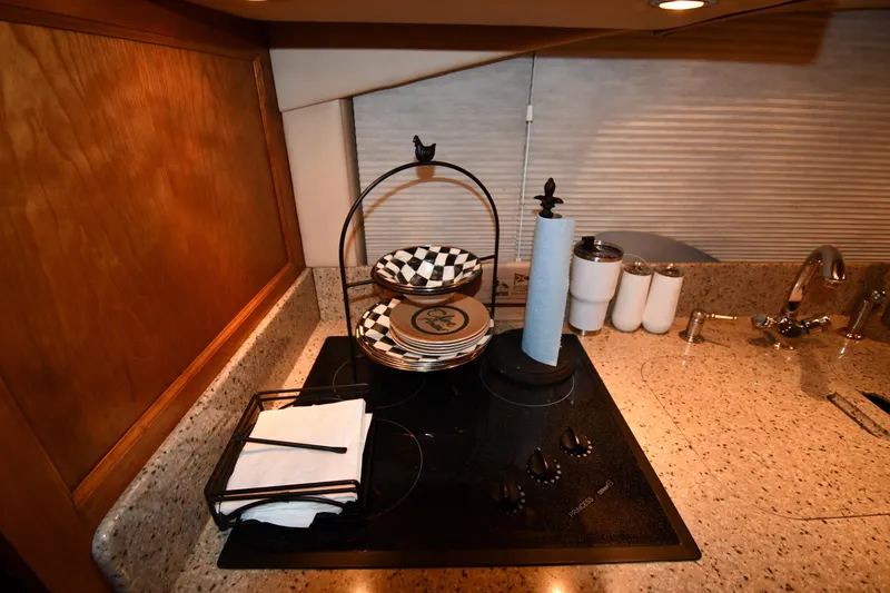 Slide: The Image of 2003 Cruisers Yachts 5000 Sedan Sport kitchen with stove, plates, and paper towel holder. - 56