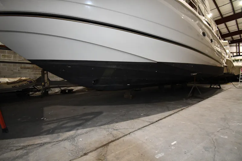 Slide: The Image of 2003 Cruisers Yachts 5000 Sedan Sport in storage, showcasing sleek hull design. - 75