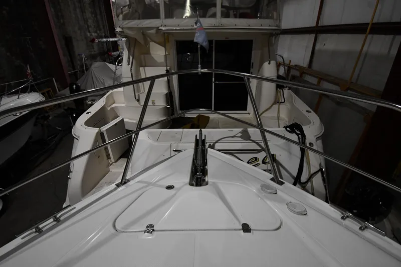 Slide: The Image of 2003 Cruisers Yachts 5000 Sedan Sport in storage, showcasing deck and railing details. - 8