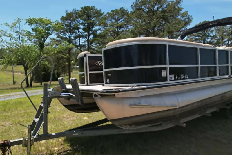 Slide: The Image of 2022 Bentley Pontoons 240 CRUISE on trailer, parked in grassy area with trees. - 2