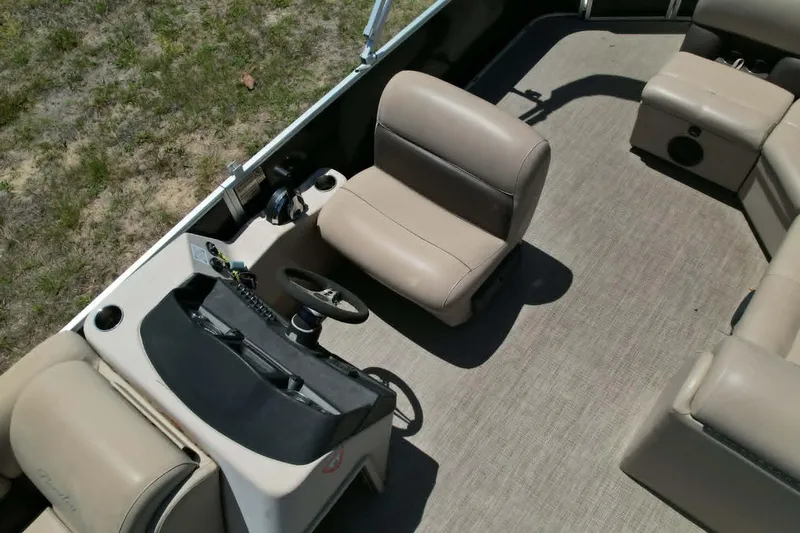 Slide: The Image of 2022 Bentley Pontoons 240 CRUISE interior with beige seating and steering console. - 4