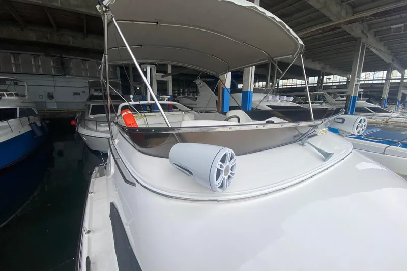 Slide: The Image of 2006 Regal Commodore 3880 yacht docked in a marina, featuring a sleek design and canopy. - 12