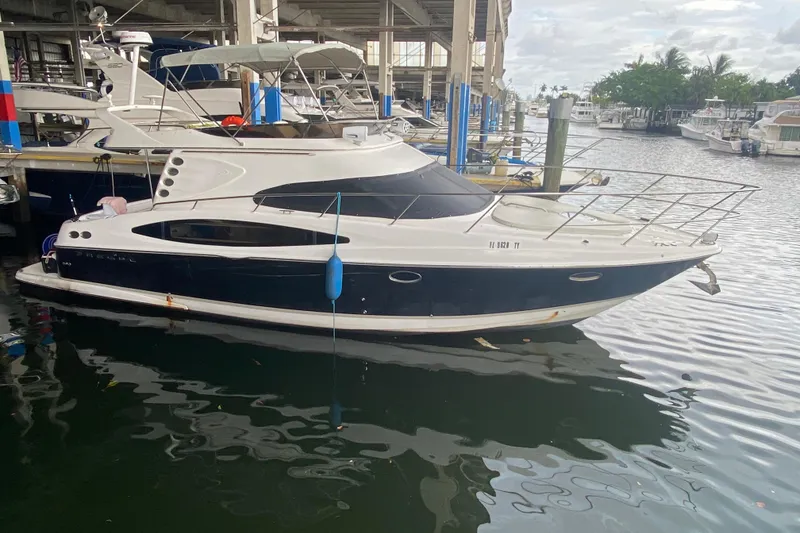 Slide: The Image of 2006 Regal Commodore 3880 yacht docked at marina, featuring sleek design and spacious deck. - 2