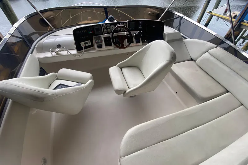 Slide: The Image of 2006 Regal Commodore 3880 boat interior with helm, white seating, and control panel. - 21