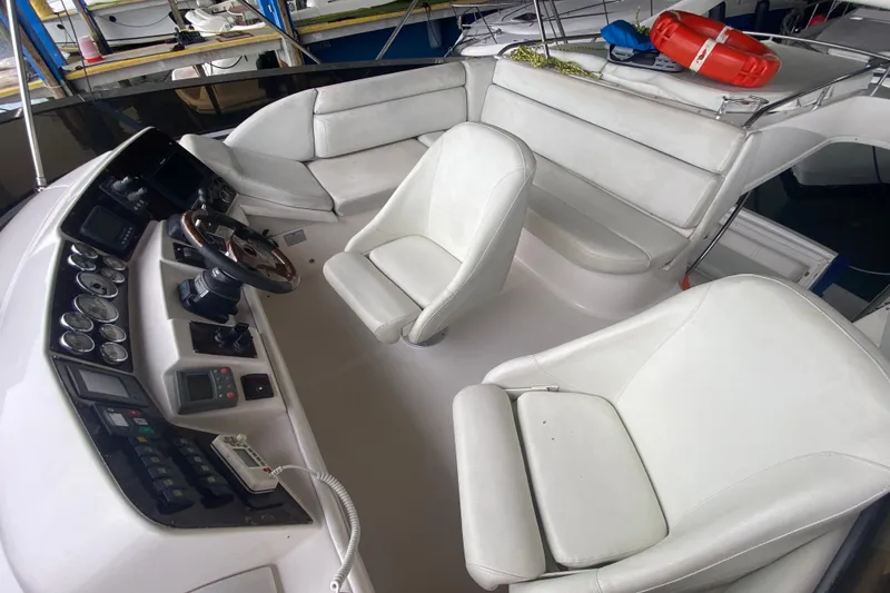 Slide: The Image of Interior of 2006 Regal Commodore 3880 boat with white seating and control panel. - 24
