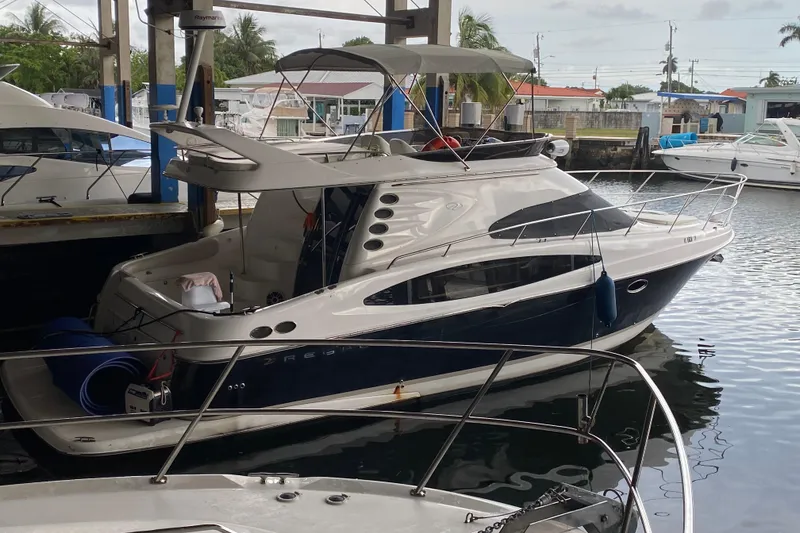 Slide: The Image of 2006 Regal Commodore 3880 yacht docked in a marina, featuring sleek design and spacious deck. - 50