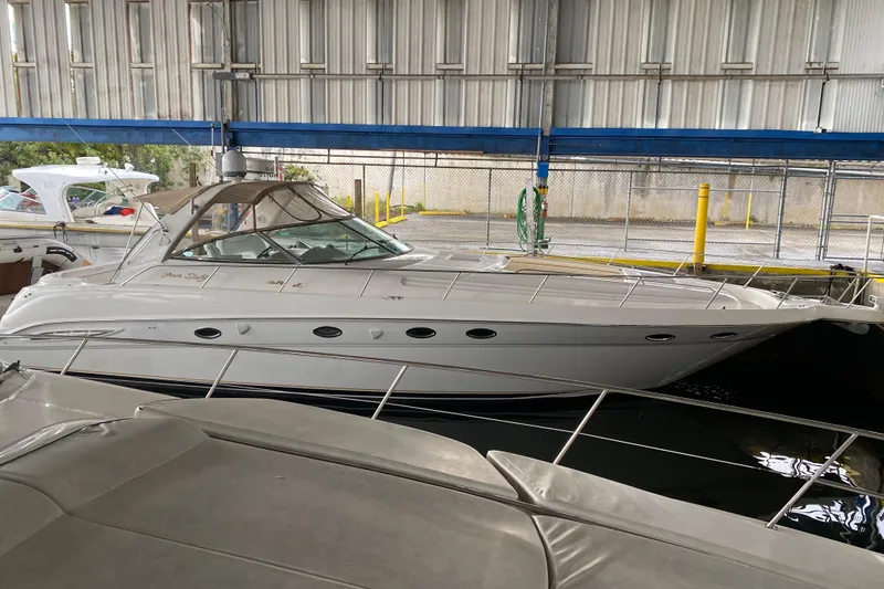 The Image of 2000 Sea Ray 460 Express Cruiser docked in a covered marina. - 0