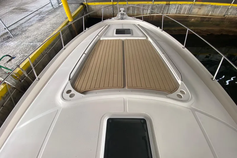Slide: The Image of 2000 Sea Ray 460 Express Cruiser bow with teak decking in a marina setting. - 13