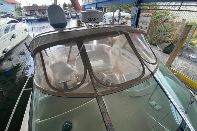 Slide: The Image of 2000 Sea Ray 460 Express Cruiser docked, featuring Garmin equipment and clear cockpit enclosure. - 30