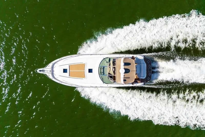 Slide: The Image of Aerial view of 2000 Sea Ray 460 Express Cruiser speeding on green water. - 31