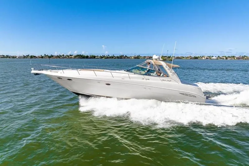 Slide: The Image of 2000 Sea Ray 460 Express Cruiser speeding on open water under clear blue skies. - 33
