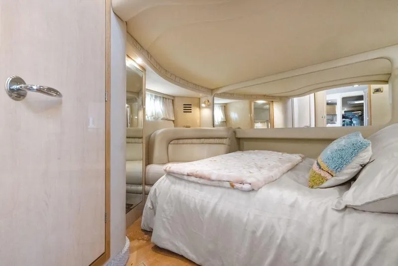 Slide: The Image of Interior of 2000 Sea Ray 460 Express Cruiser, featuring cozy bedroom with plush bedding. - 37