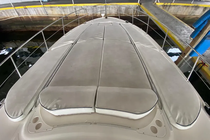 Slide: The Image of 2005 Sea Ray 500 Sundancer yacht with cushioned deck in a marina setting. - 10