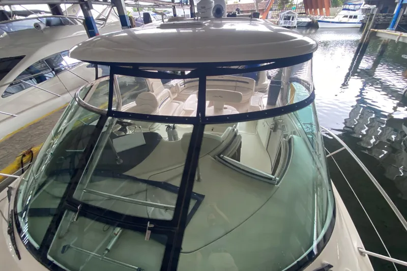 Slide: The Image of 2005 Sea Ray 500 Sundancer yacht docked, showcasing spacious cockpit and sleek design. - 13