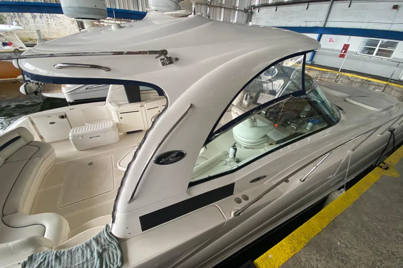 Slide: The Image of 2005 Sea Ray 500 Sundancer yacht docked in a marina, showcasing sleek design and spacious deck. - 16